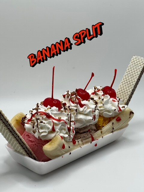 Banana split at Paletería Cuauhtémoc — three scoops under whipped cream, cherries and wafer cookies.