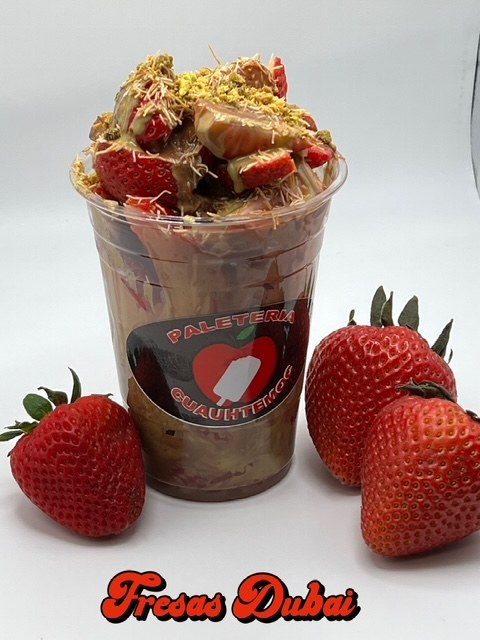 Fresas Dubai — fresh strawberries layered with chocolate, pistachio and crisp kataifi in a Paletería Cuauhtémoc cup.